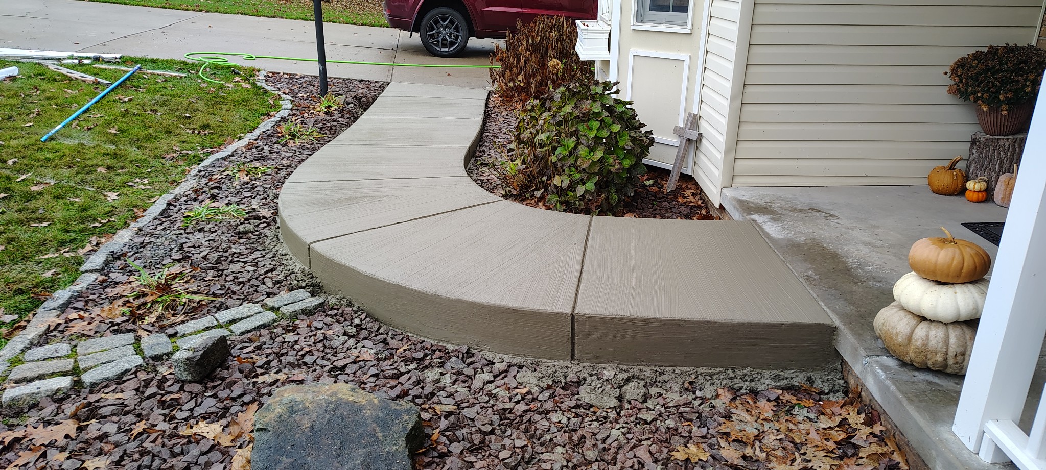 Curved concrete entry walkway beside landscaping