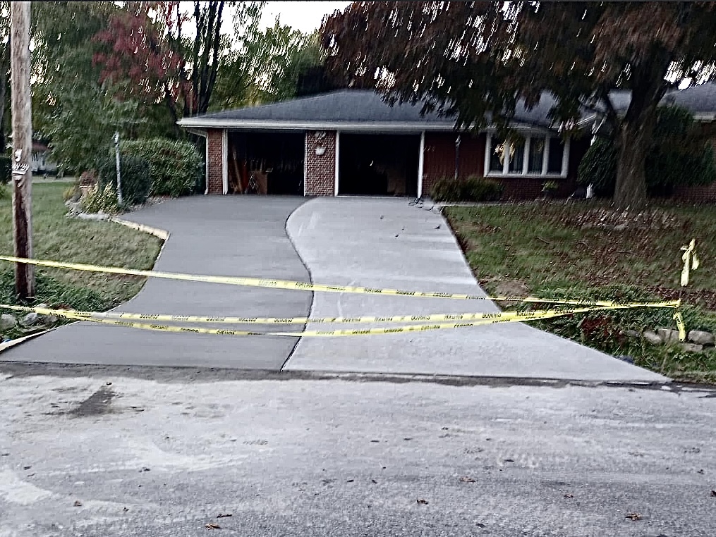 New concrete driveway leading to a residential garage