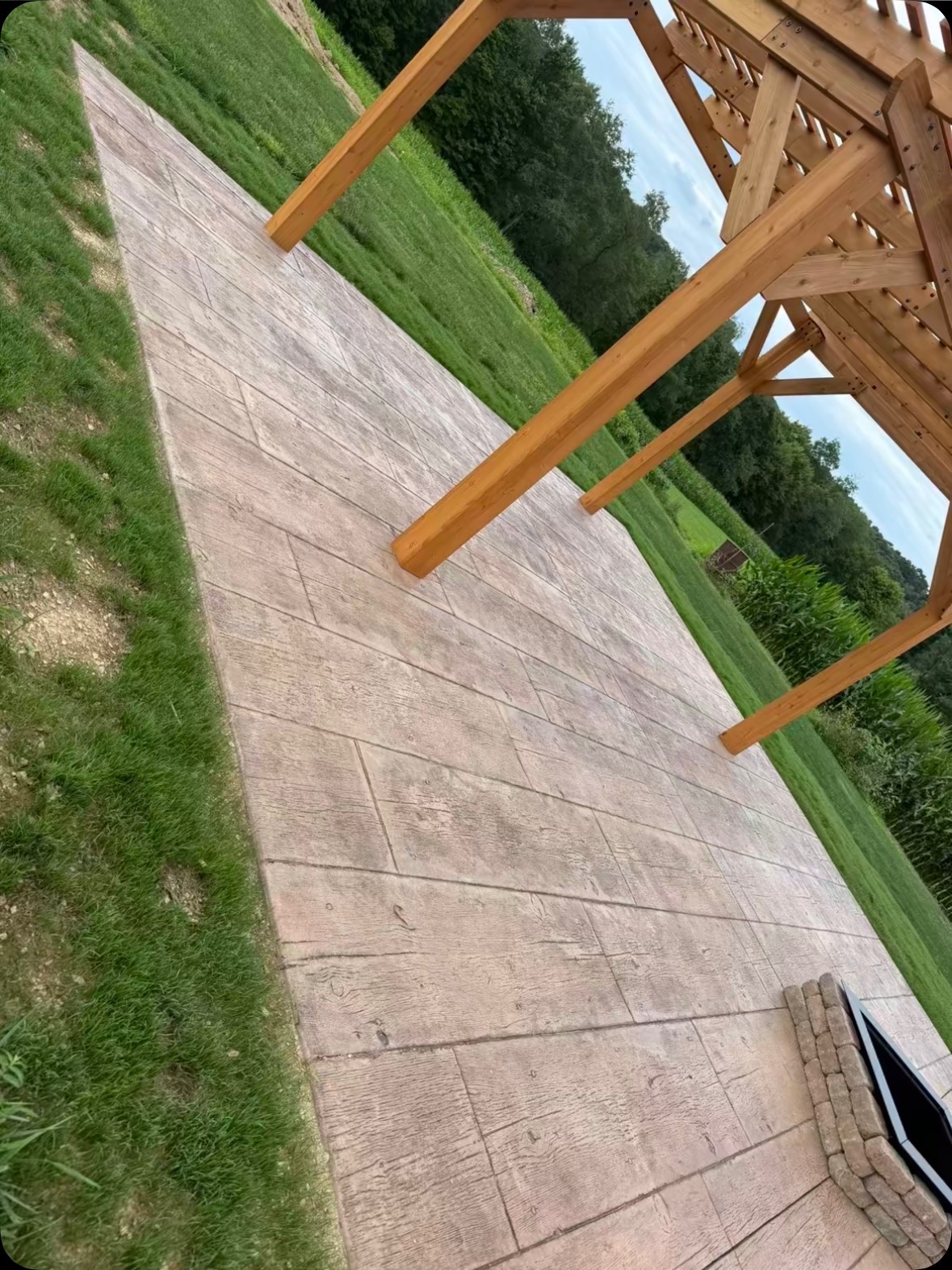Close view of stamped concrete beneath a wooden pergola