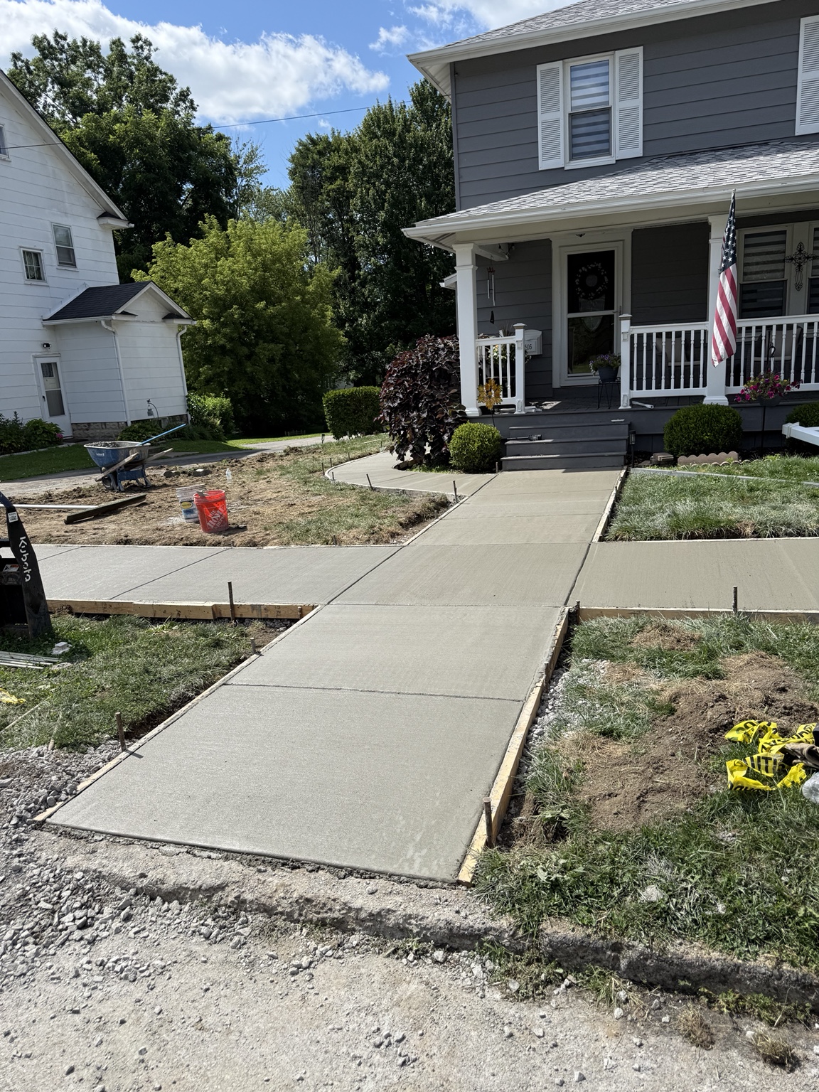 New concrete sidewalk and walkway in front of a home
