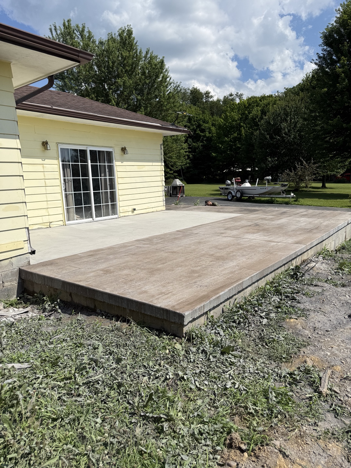 Large stamped concrete patio beside a home