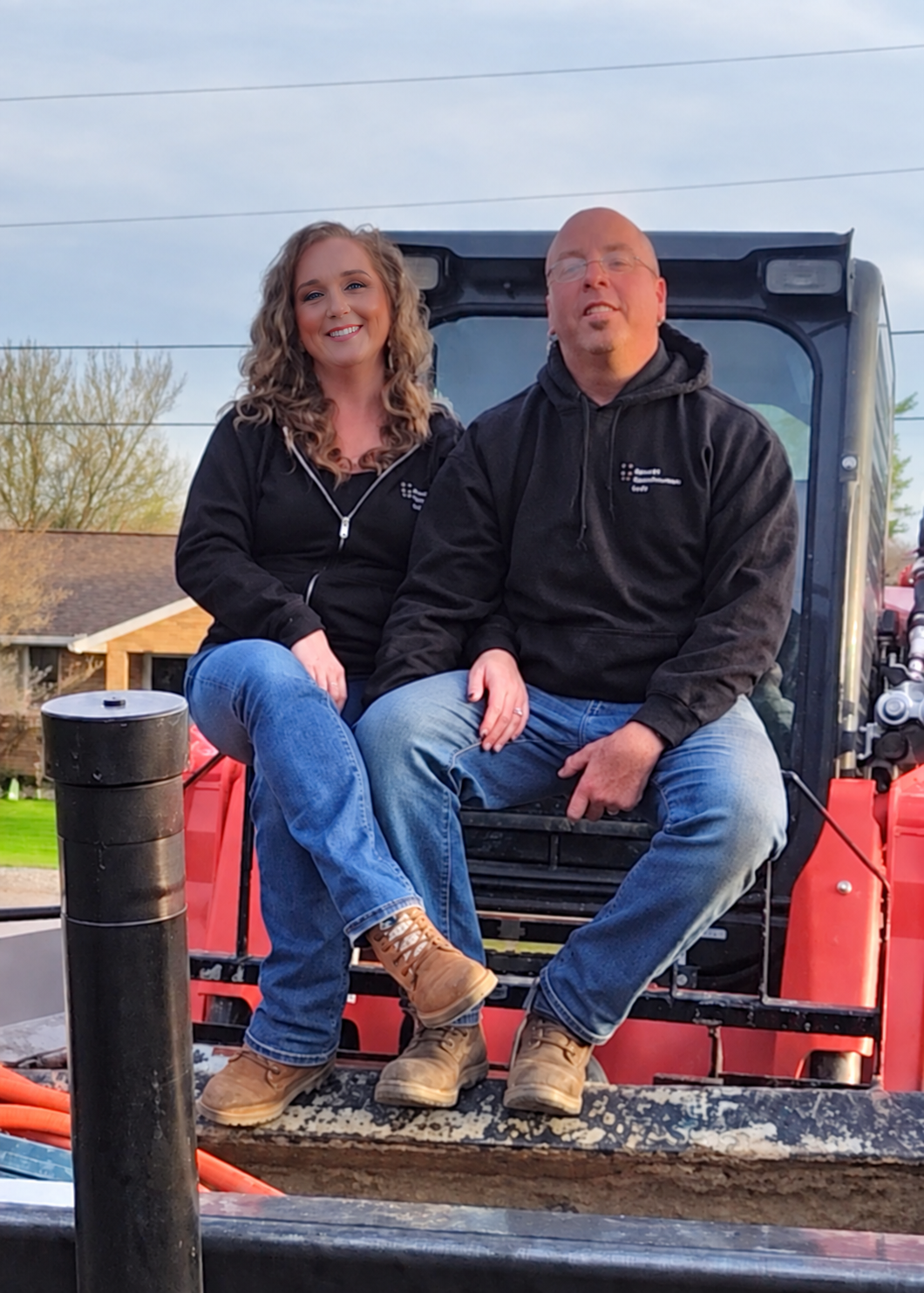 The owners of George Construction LLC seated on construction equipment