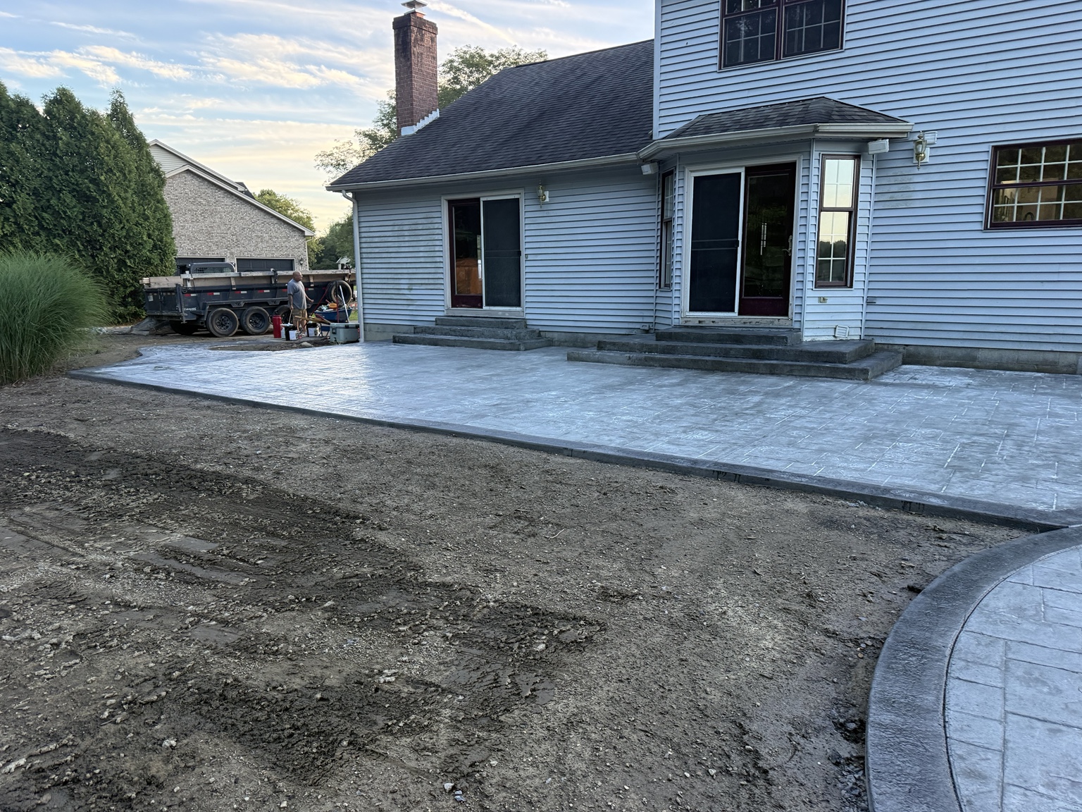 Large stamped concrete patio beside a home