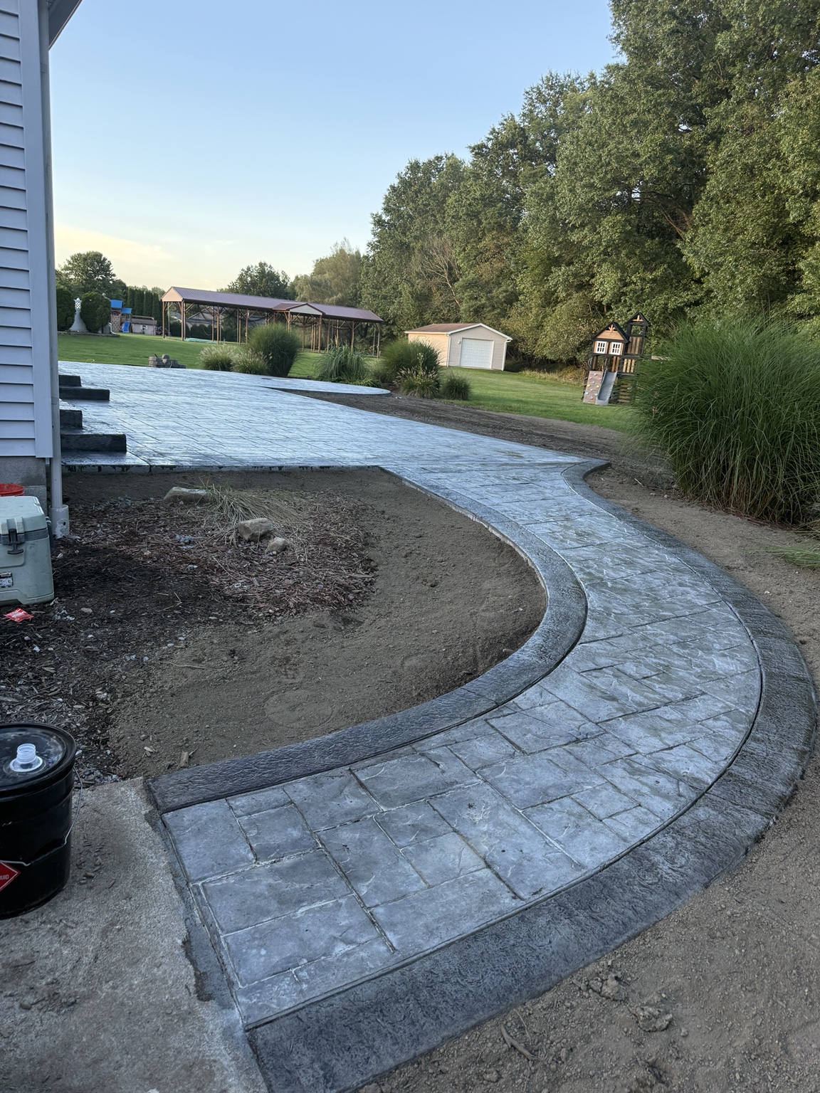 Curved stamped concrete walkway with dark border